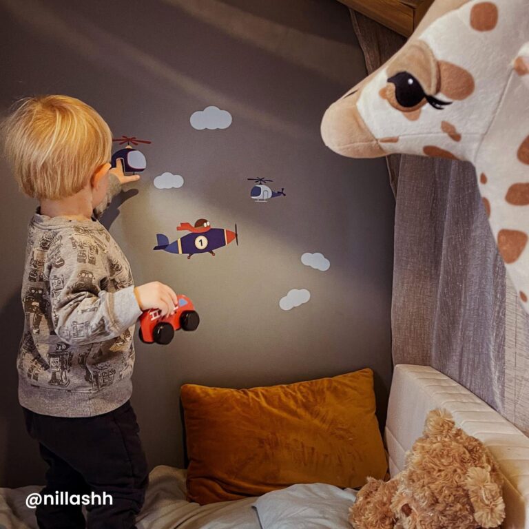 jongen die naar de naamstickers op de muur kijkt