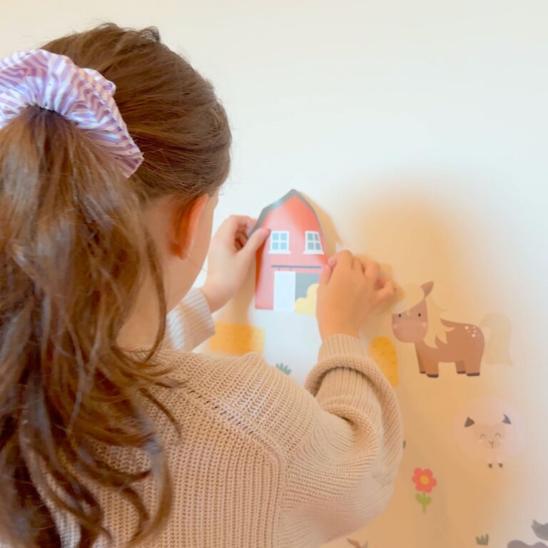 meisje plakt muurstickers op de muur