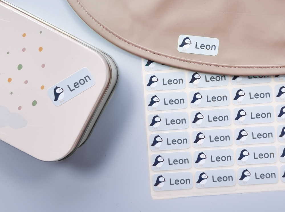 Waterbestendige naamstickers op een kinderlunchbox en stickervel