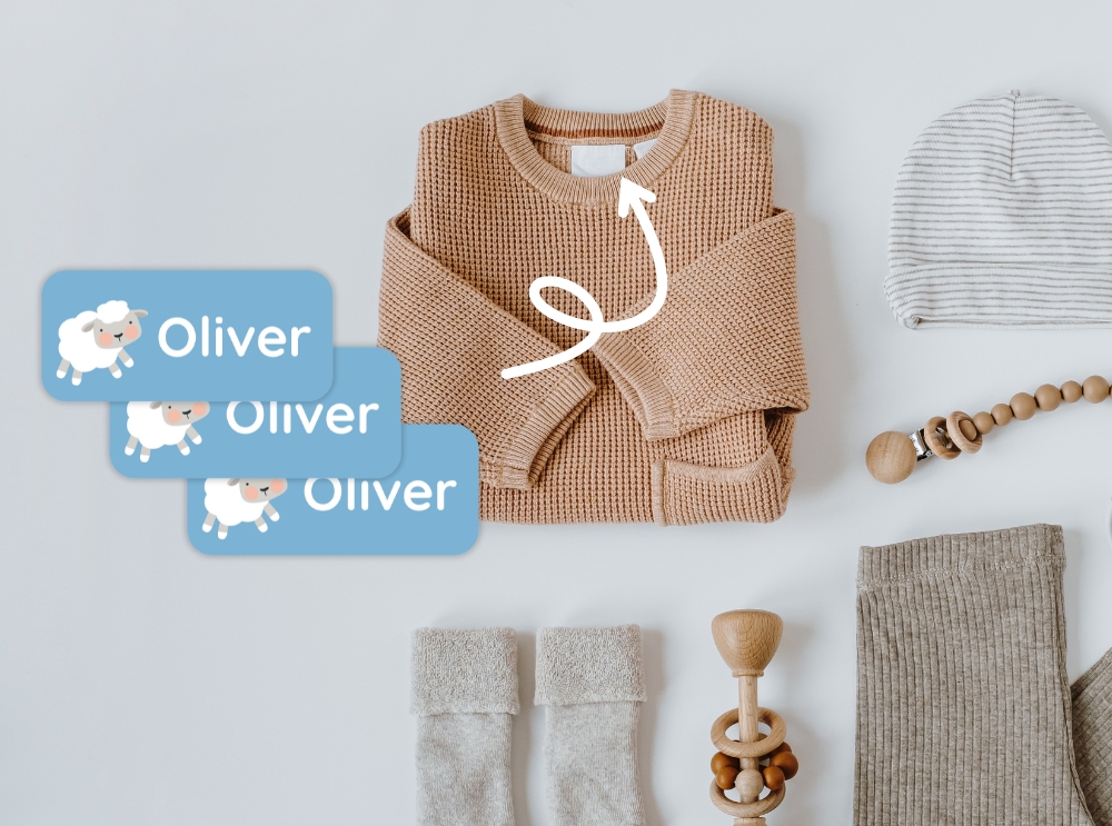 Extra kleding voor de kinderopvang: wat neem je mee en hoe blijf je georganiseerd? 1 Neutrale babykleertjes en accessoires met blauwe naamstickers met een schaapje en de naam oliver