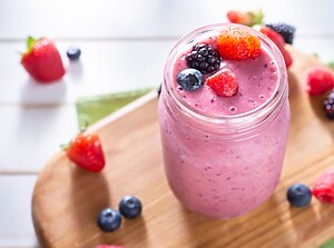 Close-up of a pink refreshing smoothie topped with fresh berries