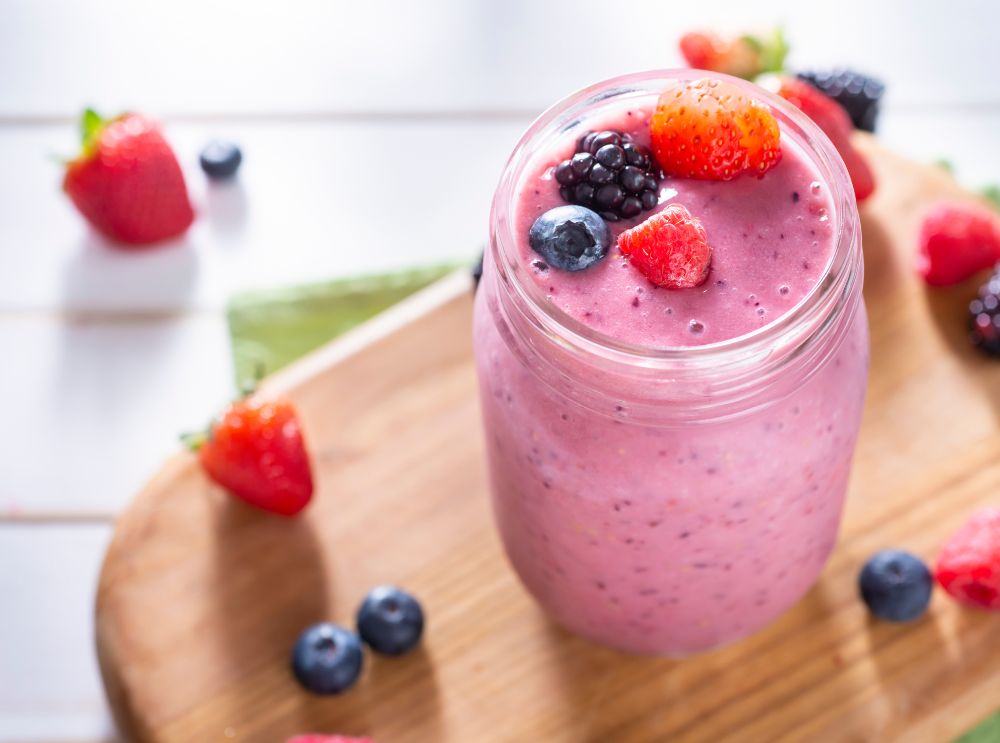 Close-up of a pink refreshing smoothie topped with fresh berries