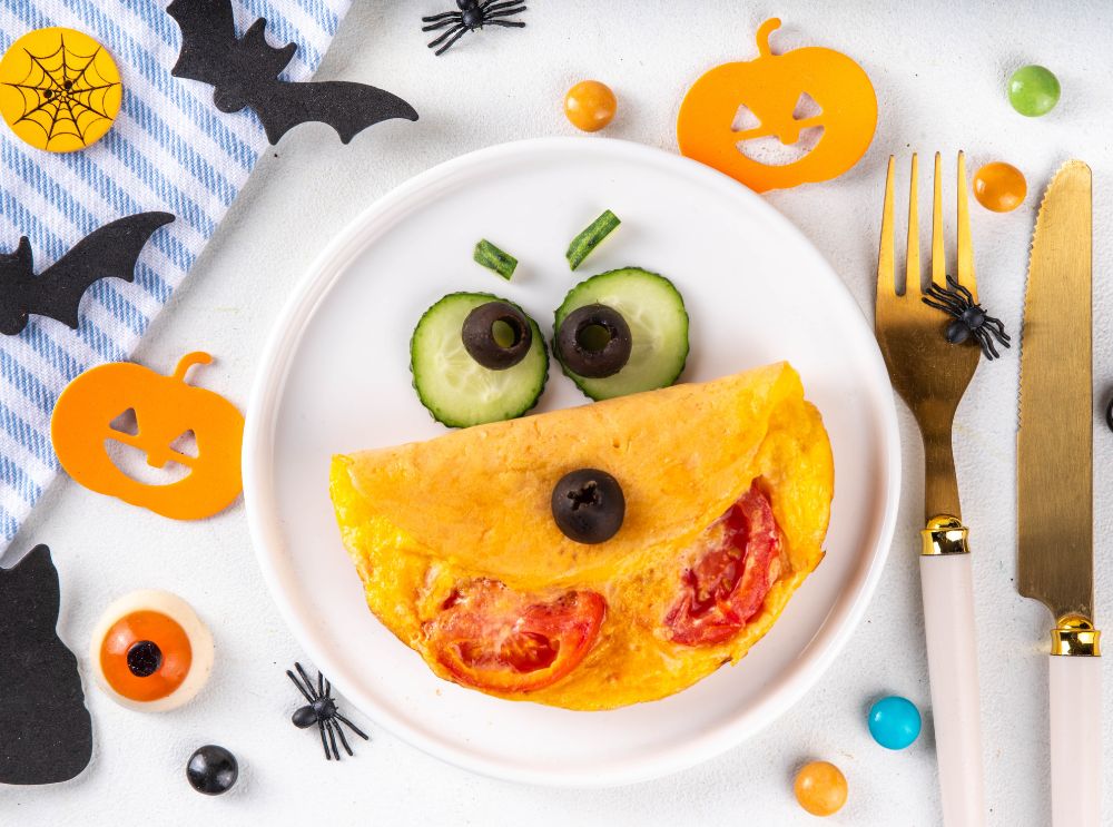 Halloweenomelet versierd met komkommer en olijven als een grappig gezicht