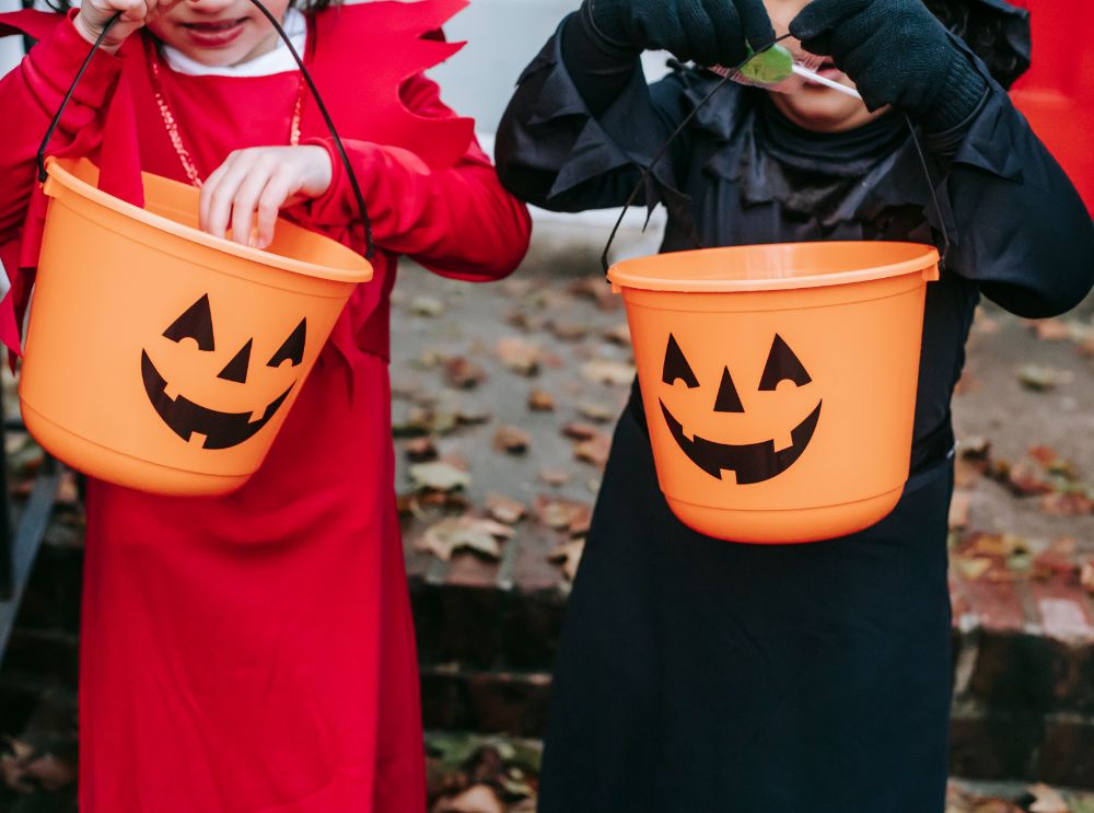 Kinderen met oranje pompoenemmer voor trick-or-treat