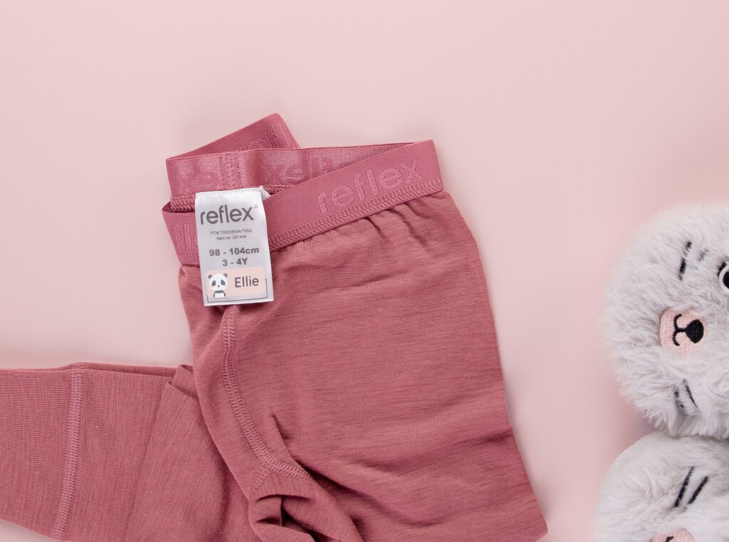 Roze kinderlegging met een gepersonaliseerd naamsticker met een panda en de naam ellie op het waslabel.