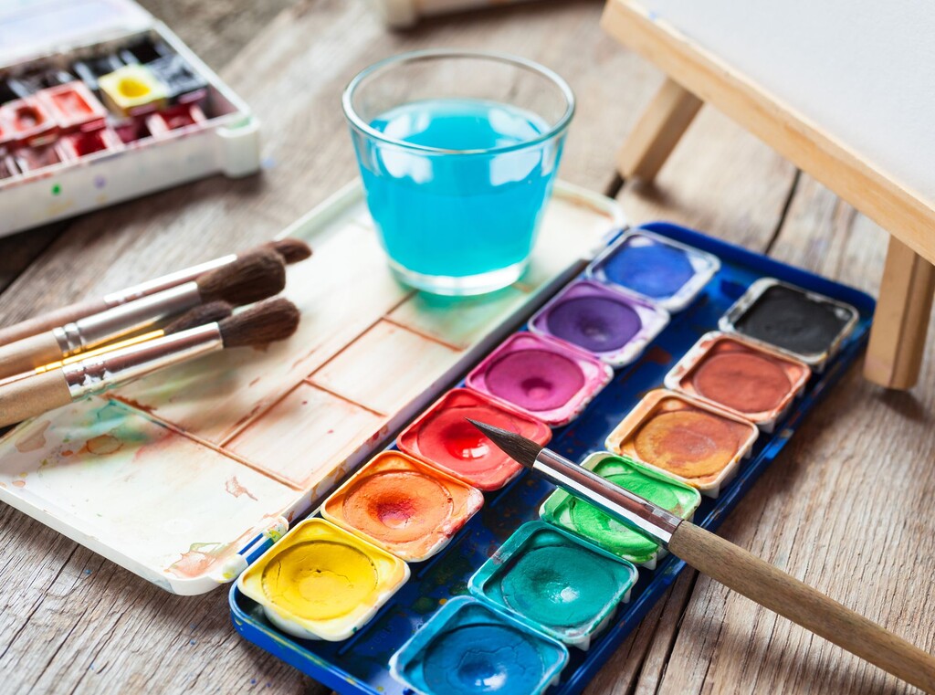 Waterverfset met kwasten en een glas water, klaar voor een leuke knutselactiviteit.