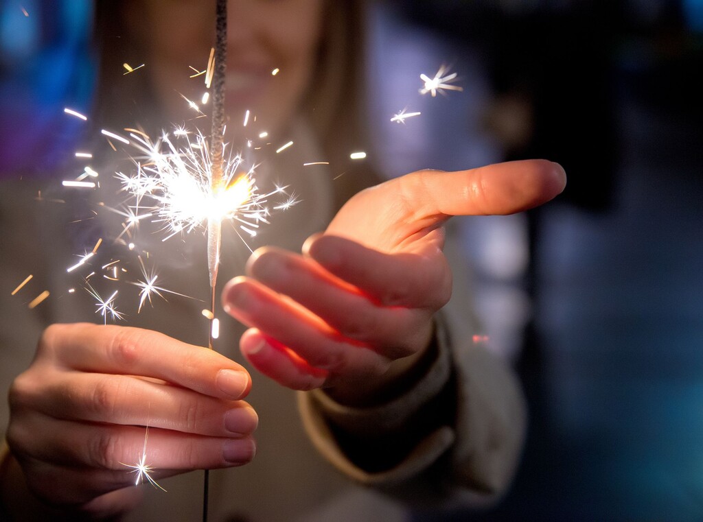 Oud en nieuw met kinderen: leuke ideeën voor een avond om nooit te vergeten 1 Kind houdt een fonkelende sterretje vast tijdens een feestelijke viering