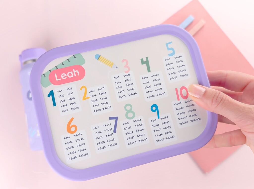 Gepersonaliseerde lunchbox met de naam leah op de deksel, van bovenaf vastgehouden.
