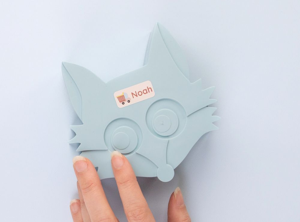 Gepersonaliseerd naamsticker met vrachtwagenmotief op een lichtblauwe doos in de vorm van een vos