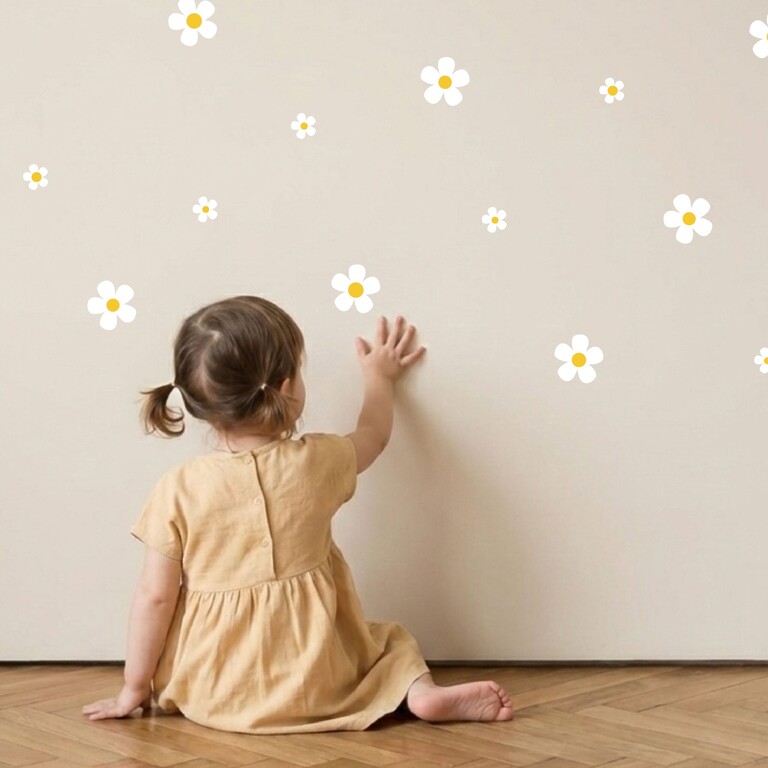 Daisy (wit) muurstickers worden door een kind op de muur geplakt
