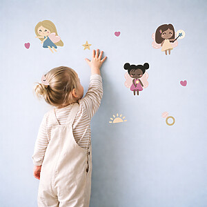 meisje plakt feeën-naamstickers op de muur