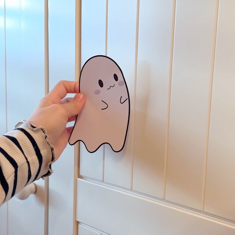 Kind plakt spookjes-muursticker op een kast